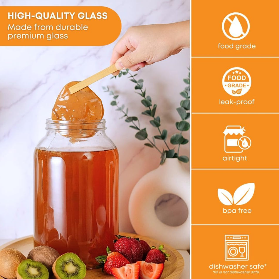Set of four 1-gallon clear glass brewing and fermentation jars by FastRack, shown with wide mouths and sealed lids for home brewing.